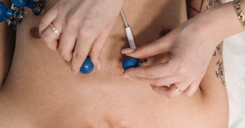Close-up of a healthcare professional placing ECG electrodes on a patient's chest for heart monitoring.